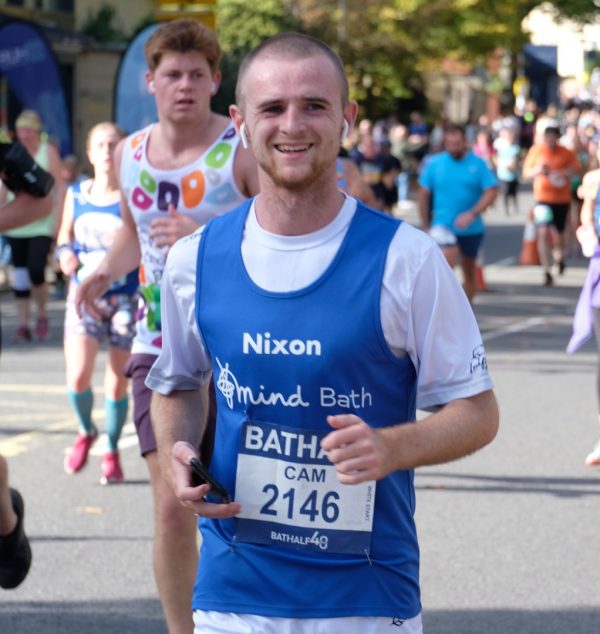 A man running wearing a Bath Mind vest