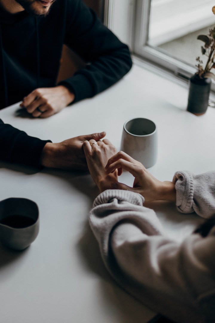 hands holding across a table