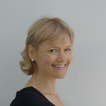 a portrait photo of a white woman with short blonde hair smiling in to the camera