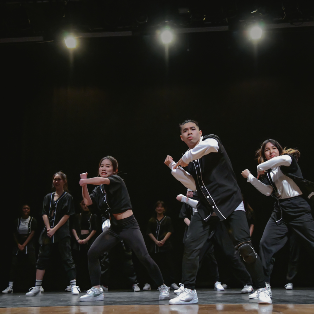 A group of people are on a stage mid-dance