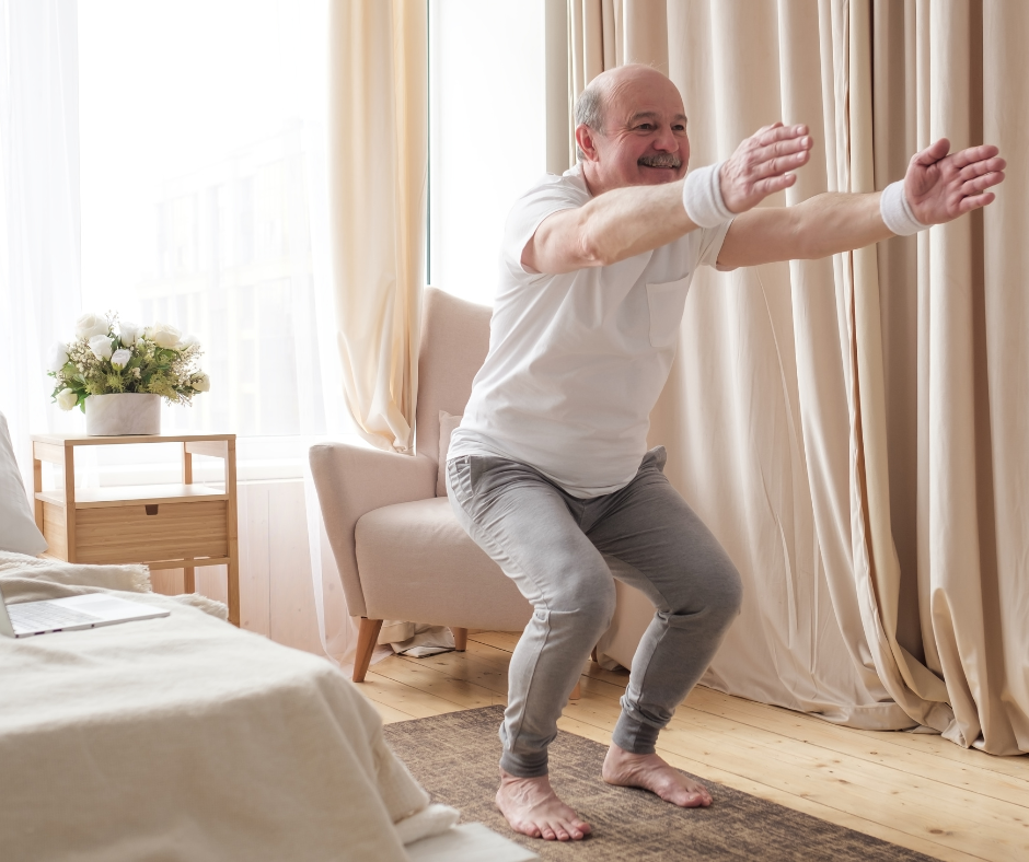 A senior man with grey hair is doing chair yoga