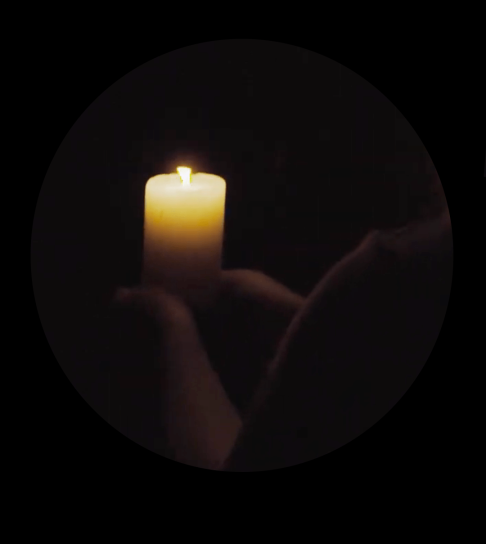 A candle held in a dark tunnel