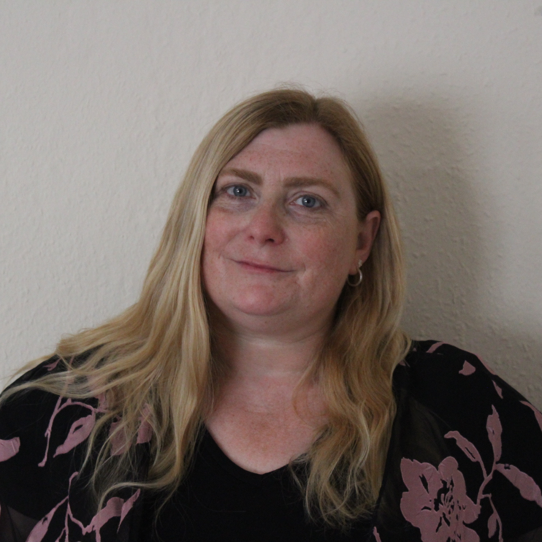 A portrait of a smiling white woman and blonde hair smiling.