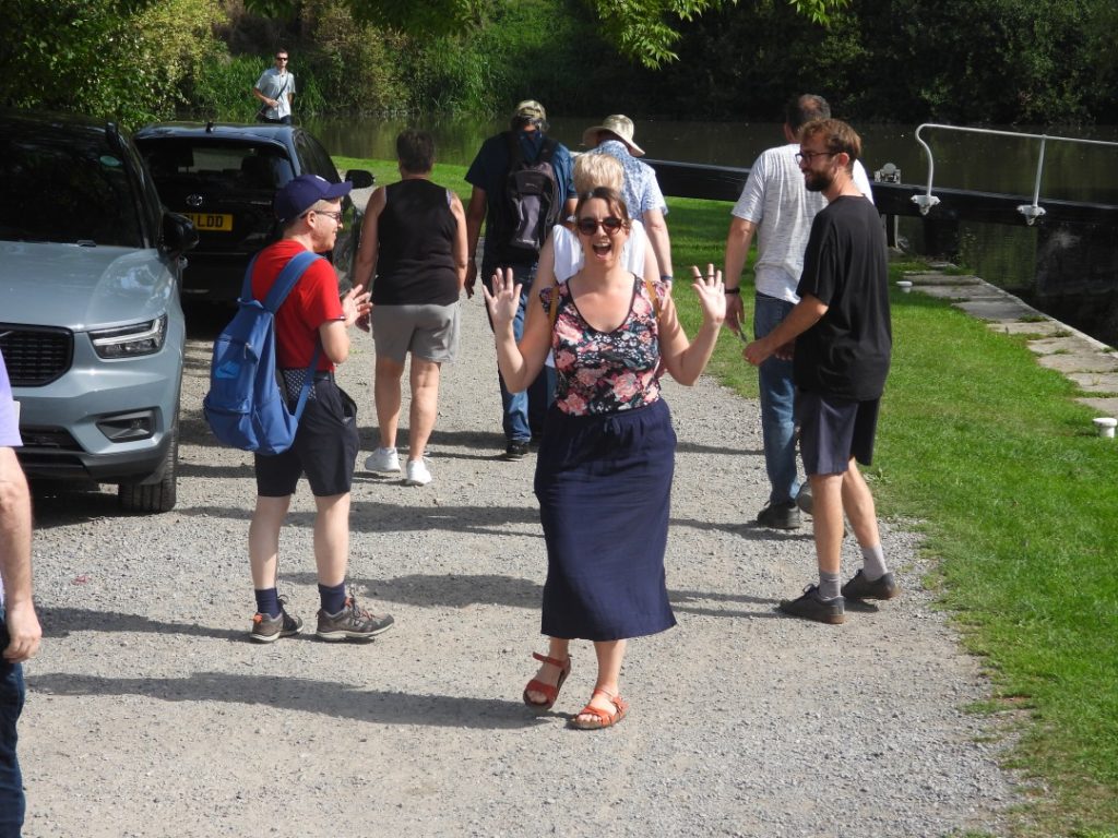 A group of people walking along the canal in Bath.