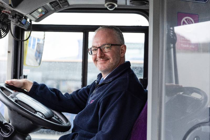 A bus driver smiling
