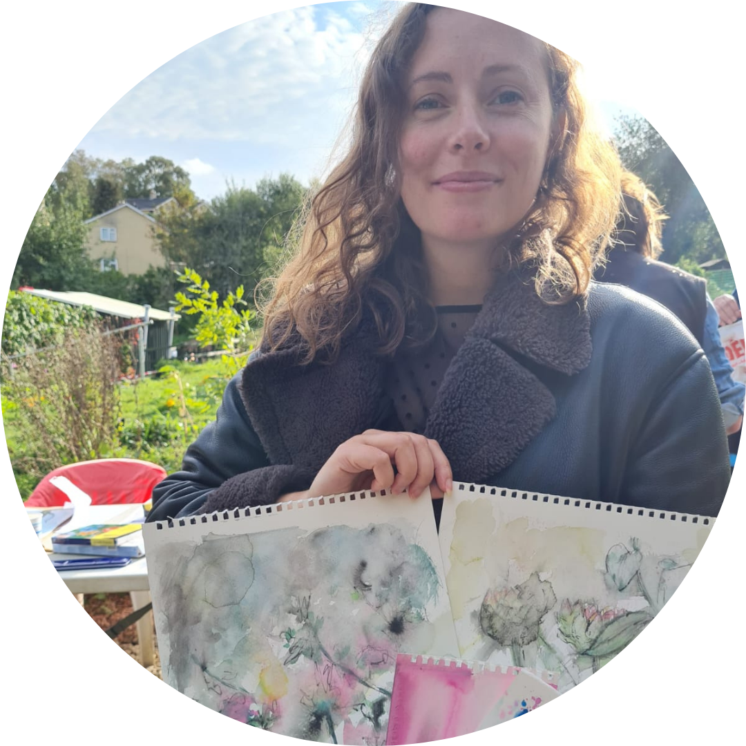 A woman holding up some watercolours art