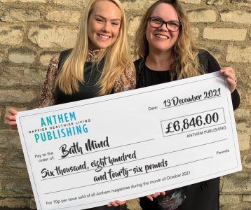 Two people holding a cheque made out to Bath Mind