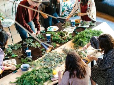 A group of people making Christmas wreaths