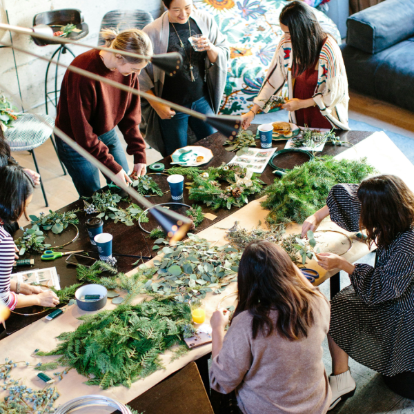 A group of people making Christmas wreaths