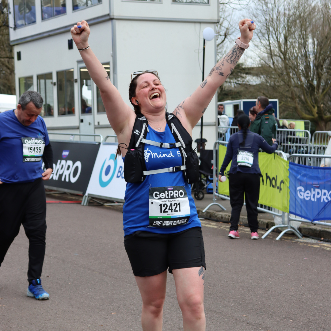A woman crossing the Bath Half finishing line