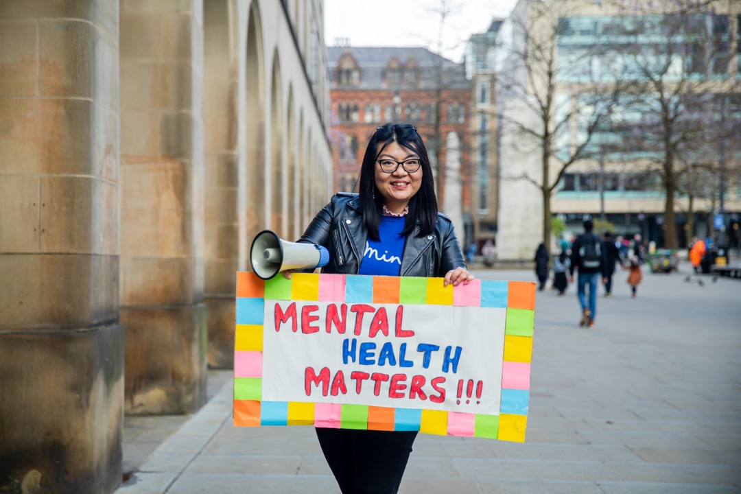 A person with a sign that reads Mental health matters