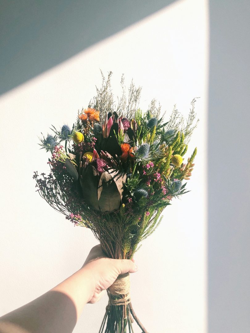 A hand holding a natural style bouquet