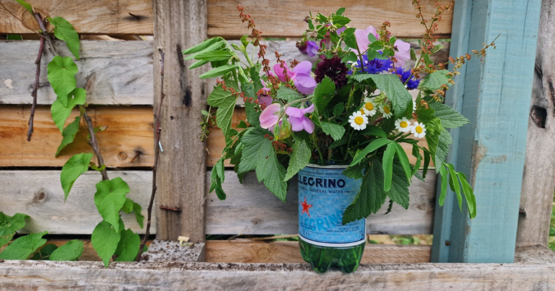 floral table decoration in a recycled water bottle